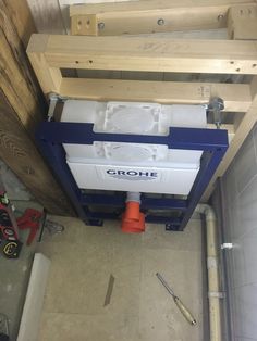 a white and blue cooler sitting on top of a wooden floor next to a wall