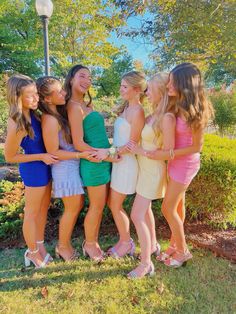 a group of young women standing next to each other in front of a lamp post