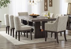 a dining room table with chairs and a bowl of fruit on top of the table