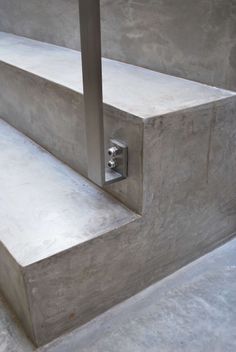 a concrete bench with a metal handle on it