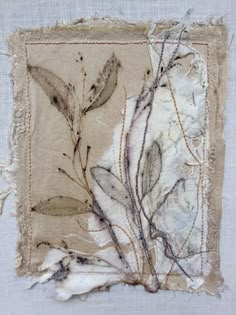 a piece of fabric with leaves and twigs on it, in the middle of a white background