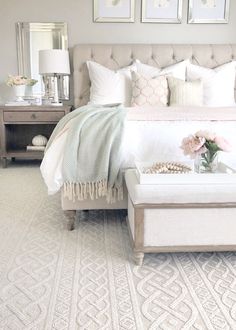 a bedroom with white bedding and pictures on the wall