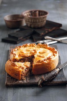 a pie on a cutting board with one slice cut out