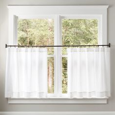 a white bed sitting under a window in a bedroom