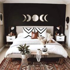 a white bed sitting in a bedroom next to two planters on top of a rug