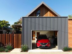 a red car is parked in the garage with it's door open to let people inside