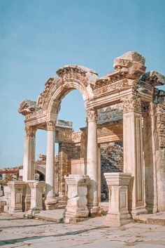 an old building with columns and arches in the middle of it's stone floor