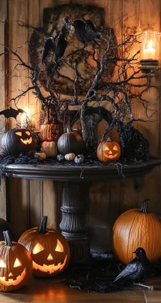 halloween decorations with carved pumpkins and candles on a table in front of a wood paneled wall