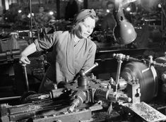 an old black and white photo of a man working in a factory