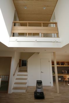 a luggage bag sitting in the middle of a living room under a stair case next to a window