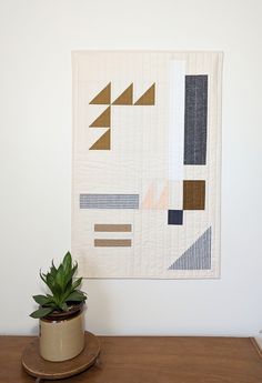 a potted plant sitting on top of a wooden table next to a white wall