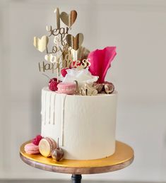 a white cake with pink and gold decorations