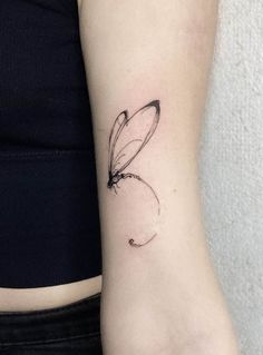 a woman's arm with a small butterfly tattoo on the left side of her arm