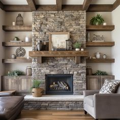 a living room with a stone fireplace and wooden shelves