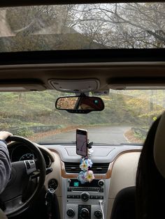 two people in the driver's seat of a car looking at their cell phone