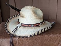 A hat for all occasions! The hat body is a very soft hat and has been flame distressed. The brim is 4" and has a wire in it to shape it further. The crown is 5". This hat has stampede strings so it stays on in those high winds. Hand laced in brown leather The layered hat band is brown leather with Southwestern imprinted whiskey brown leather and accented with sunburst sliders and nailspots. The back of the band has a deer antler bead. Finished with a long Ringneck Pheasant feather and smaller ph Antler Beads, Talc Powder, Pheasant Feather, Hat Holder, Soft Hats, Cloth Tape, Pheasant Feathers, Sweat Stains, Felt Hat