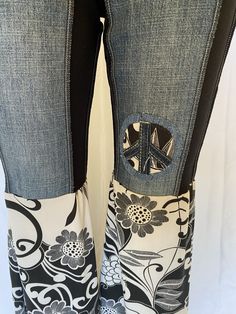 a pair of jeans with flowers and peace sign on them