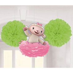 a stuffed animal hanging from the ceiling with green pom - poms around it