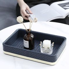 a bottle and candle are on a tray