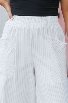 These linen wide leg pants are perfect for everyday wear and beach vacations! Expertly crafted with a smocked waistband and front pockets, these Oatmeal Striped Linen Wide Leg Pants offer both style and functionality. The frayed detail adds a touch of edginess, while the blend of 55% linen and 45% rayon ensures comfort and durability. Perfect for any occasion! Style with a basic tank top, comfy slide sandals, and a woven crossbody bag for a chic vacay-ready outfit! White Wide Leg Pants With Pockets For Beach, White Pants With Elastic Waistband For Beach, High-waist Cotton Wide Leg Pants For Vacation, High Waist Wide Leg Cotton Pants For Vacation, High Waist Cotton Wide Leg Pants For Vacation, White Beach Pants With Elastic Waistband, White Cotton Wide Leg Pants For Vacation, High Waist Cotton Wide Leg Vacation Pants, Cotton Wide Leg Pants For Beach Season