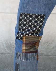 a person wearing blue jeans and a patchwork pocket