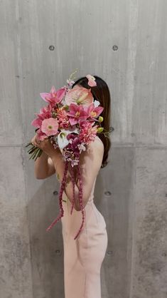 a woman holding a bouquet of flowers in front of her face