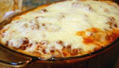 a casserole dish with cheese and meat in it sitting on a kitchen counter