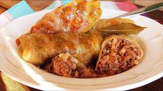 a white plate topped with stuffed cabbage and meat