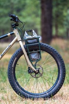 a bicycle parked in the grass near some trees