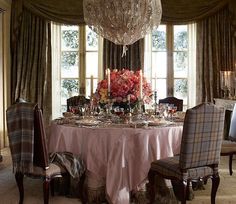 a dining room table is set with flowers and candles