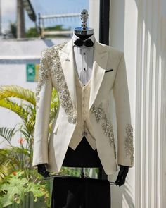 Make an edgy statement with White EMBROIDERED suit designed thoughtfully for the modern  man. A fusion staple fit for every occasion, adds the right amount of cultural twist to the western silhouette. Color: white Garment Type: Indo Western Neck: tuxedo Fabric: Micro Velvet Embroidery: Zari work with sequin embroidery The Product Price is inclusive of: 1 Indo-Western and 1 Trouser Style Bottom and 1 shirt Product color may slightly vary due to photographic lighting sources or your screen setting Fitted Notch Lapel Tuxedo For Wedding, Tailored Tuxedo Blazer For Wedding, Fitted White Suit For Wedding, Fitted Tuxedo Sets For Weddings, Fitted Tuxedo Blazer For Wedding, Fitted Tuxedo Style Blazer For Wedding, White Three-piece Suit With Notch Lapel For Party, Tuxedo Style Blazer With Suit Collar For Wedding, Ceremony Tuxedo Blazer