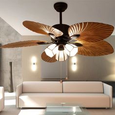 a living room with a white couch and a ceiling fan in the middle of it