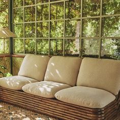 a couch sitting on top of a wooden floor next to a window covered in glass blocks