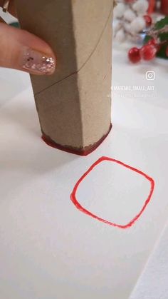 someone is stamping on the paper with a red marker to make a small square