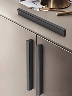 a close up view of the handles on a stainless steel kitchen cabinet with utensils