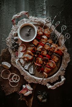 an overhead view of food on a platter with spoons and utensils