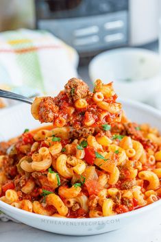 a white bowl filled with pasta and meat