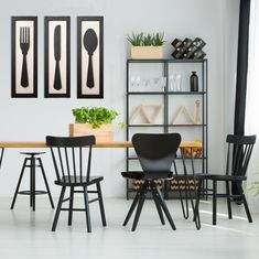 a dining room with black chairs and white walls