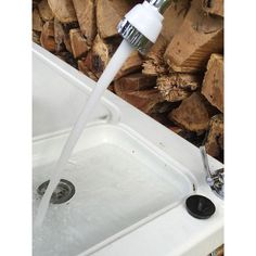 a faucet that is connected to the side of a sink with water running from it