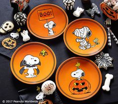 three orange plates decorated with snoopy and charlie the peanutshells characters on them