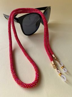 This vibrant and colorful red crochet beaded glasses chain is a must-have accessory for your eyewear collection. Handmade with love and attention to detail, it adds a unique touch of style to your glasses. The crochet design brings a boho flair, while the red beaded accents create a stunning and eye-catching look. The multicolored beads complement the red color, making it a versatile accessory that pairs beautifully with any outfit. This handcrafted glasses chain not only keeps your glasses clos Beaded Glasses Chain, Beaded Glasses, Handmade Eyewear, Glasses Strap, Red Crochet, Spooky Gifts, Color Making, Crochet Design, Glasses Chain