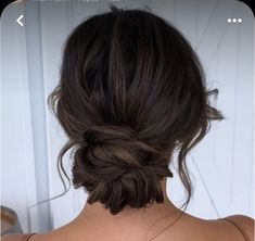 the back of a woman's head with her hair in a low bun