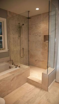 a bathroom with a walk in shower next to a bath tub