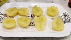 sliced bananas on a white plate sitting on a marble counter top next to ketchup bottles