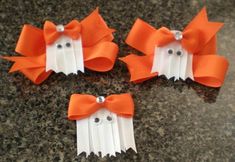 three orange and white hair clips with bows