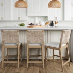 two wooden chairs sitting in front of a kitchen island