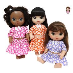 three dolls are standing next to each other on a white background, one is wearing a flowered dress and the other has long brown hair