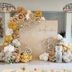 a table topped with balloons and flowers next to a wall