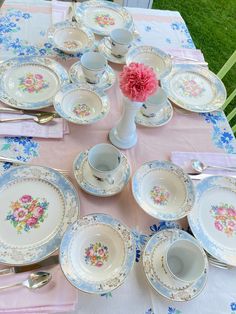 the table is set with plates, cups and saucers