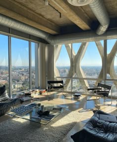 a living room filled with lots of furniture and large windows overlooking the cityscape